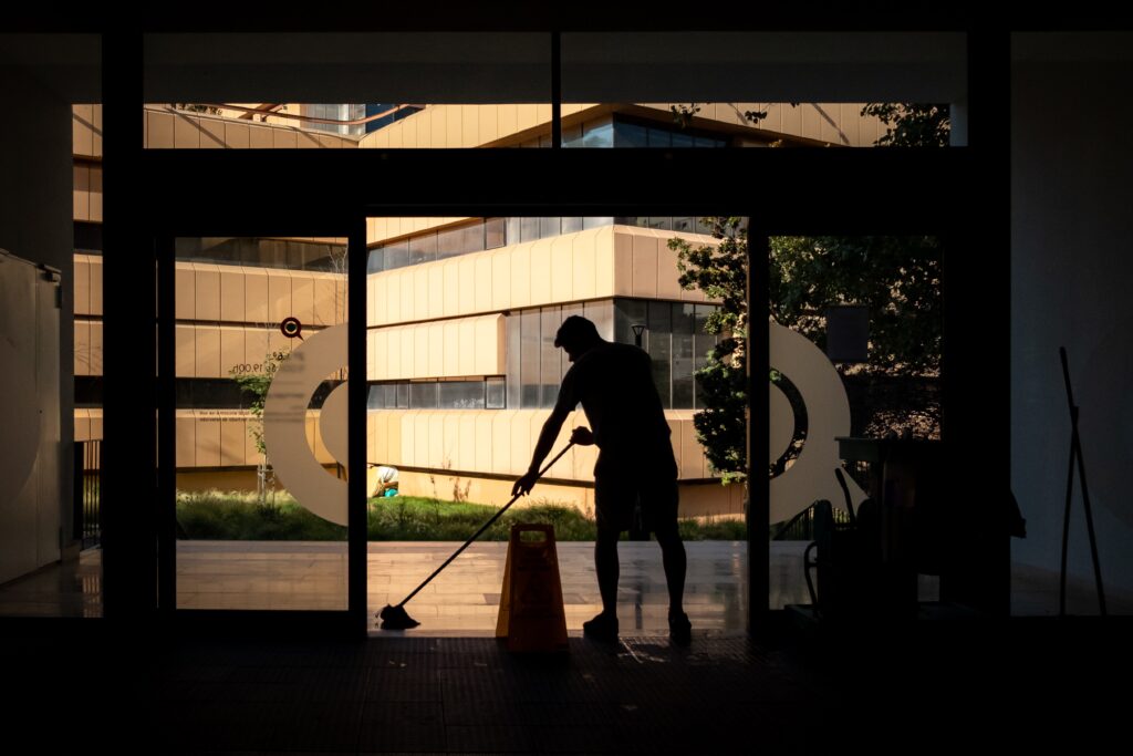 Man mopping a floor in front of an open door