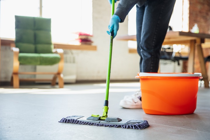 Person using a mop to clean a floor